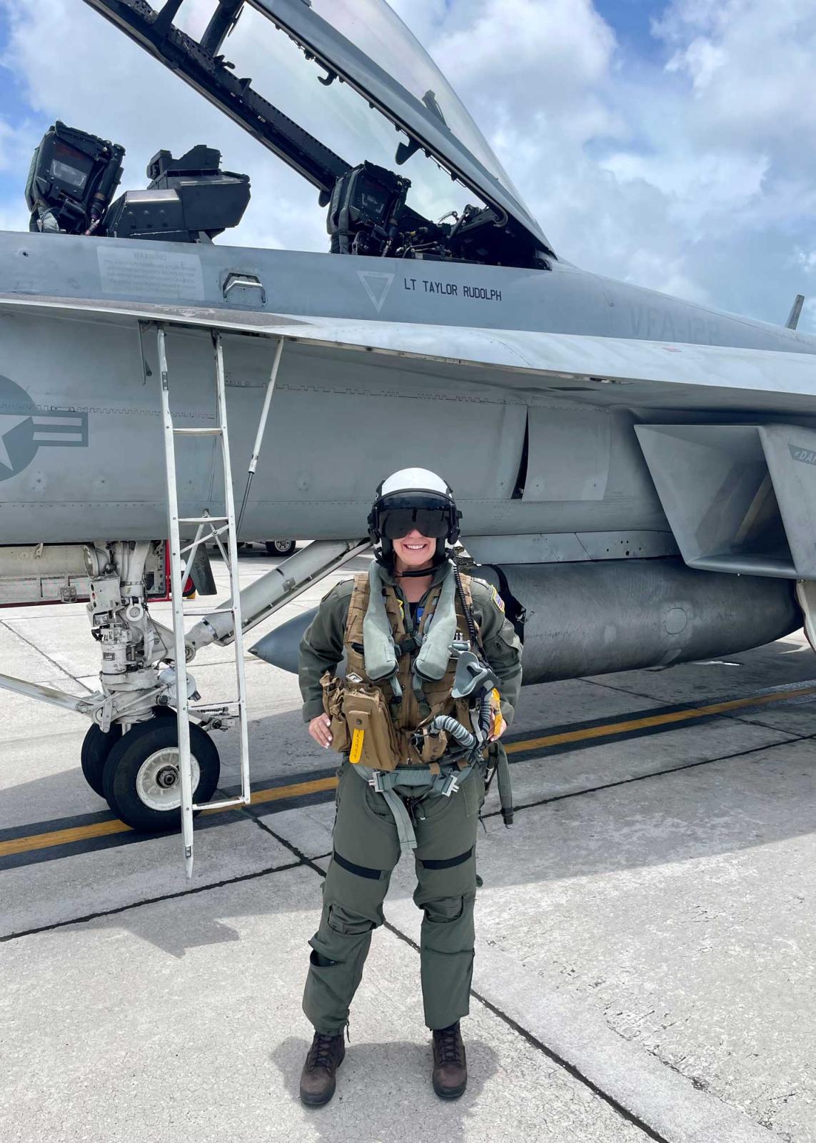 Taylor Rudolph posing in flight suit in front of her jet
