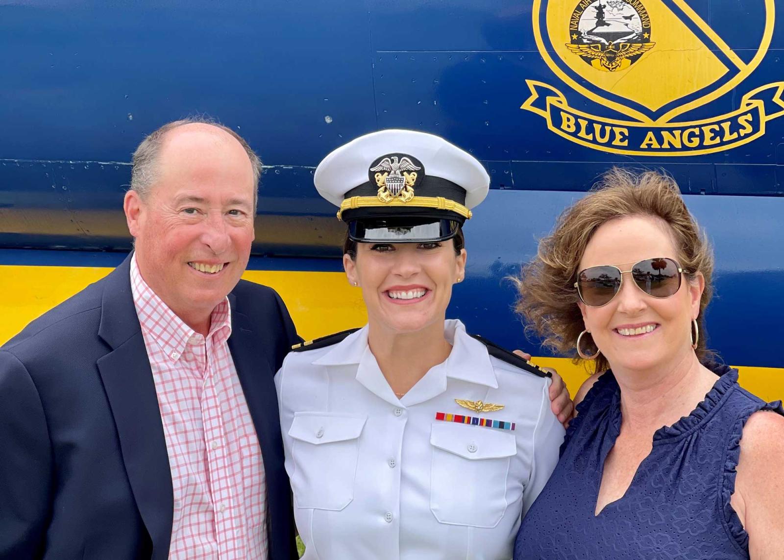 Taylor Rudolph posing with parents in front of Blue Angels jet