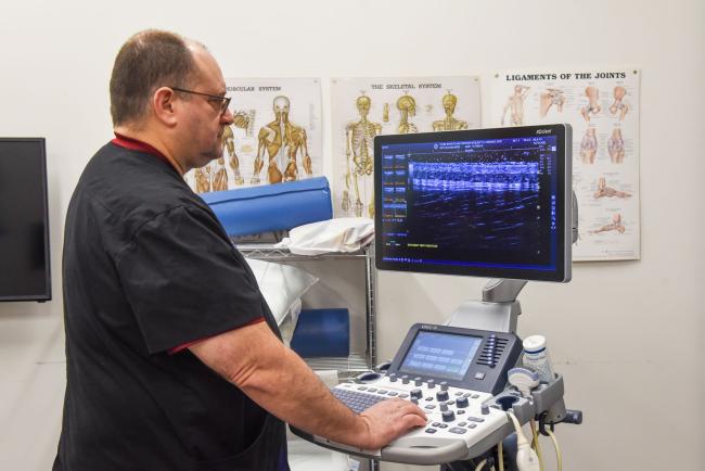 Dr. Kozar looking at the screen of an ultrasound machine