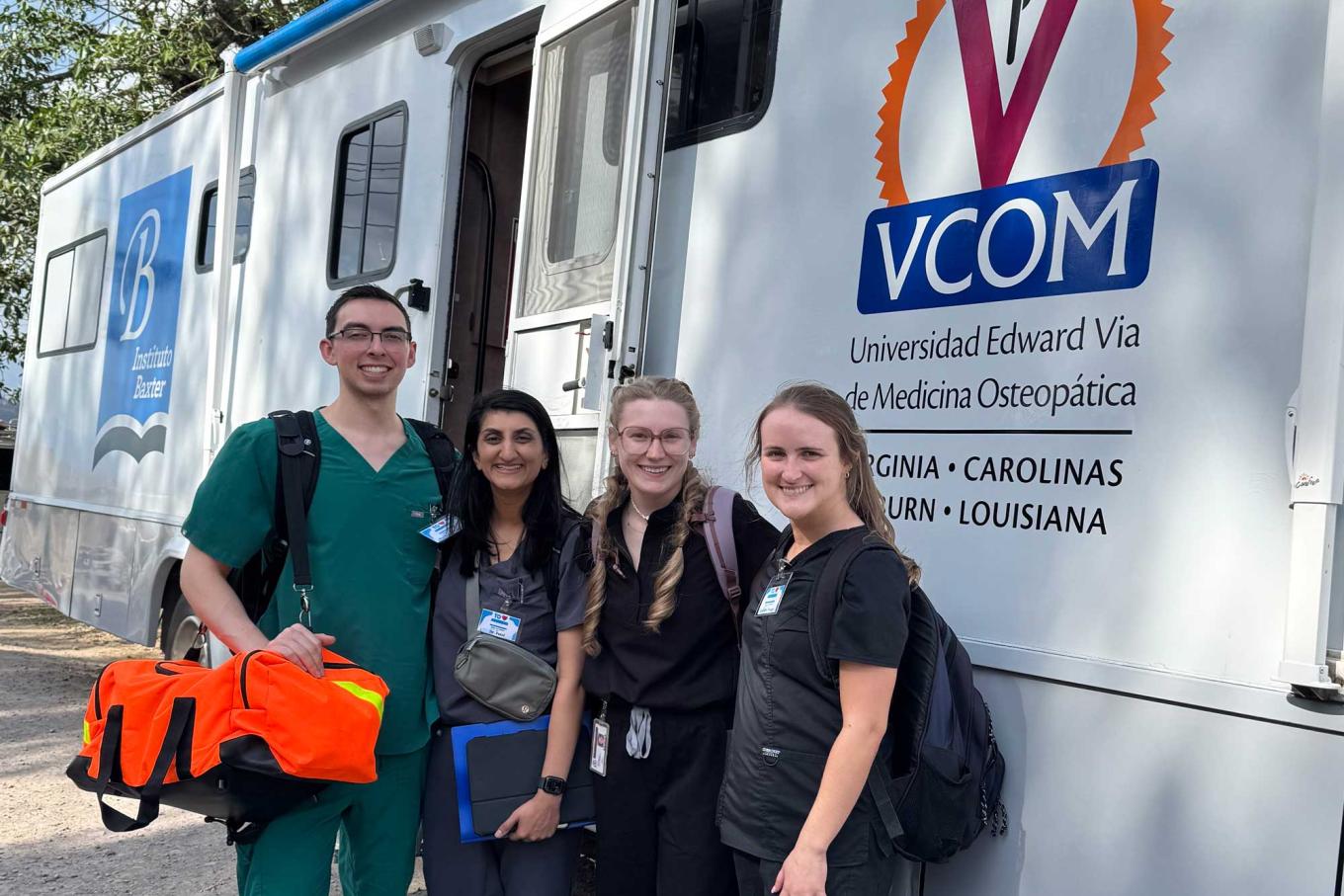 Students standing in front of a VCOM mobile medical unit