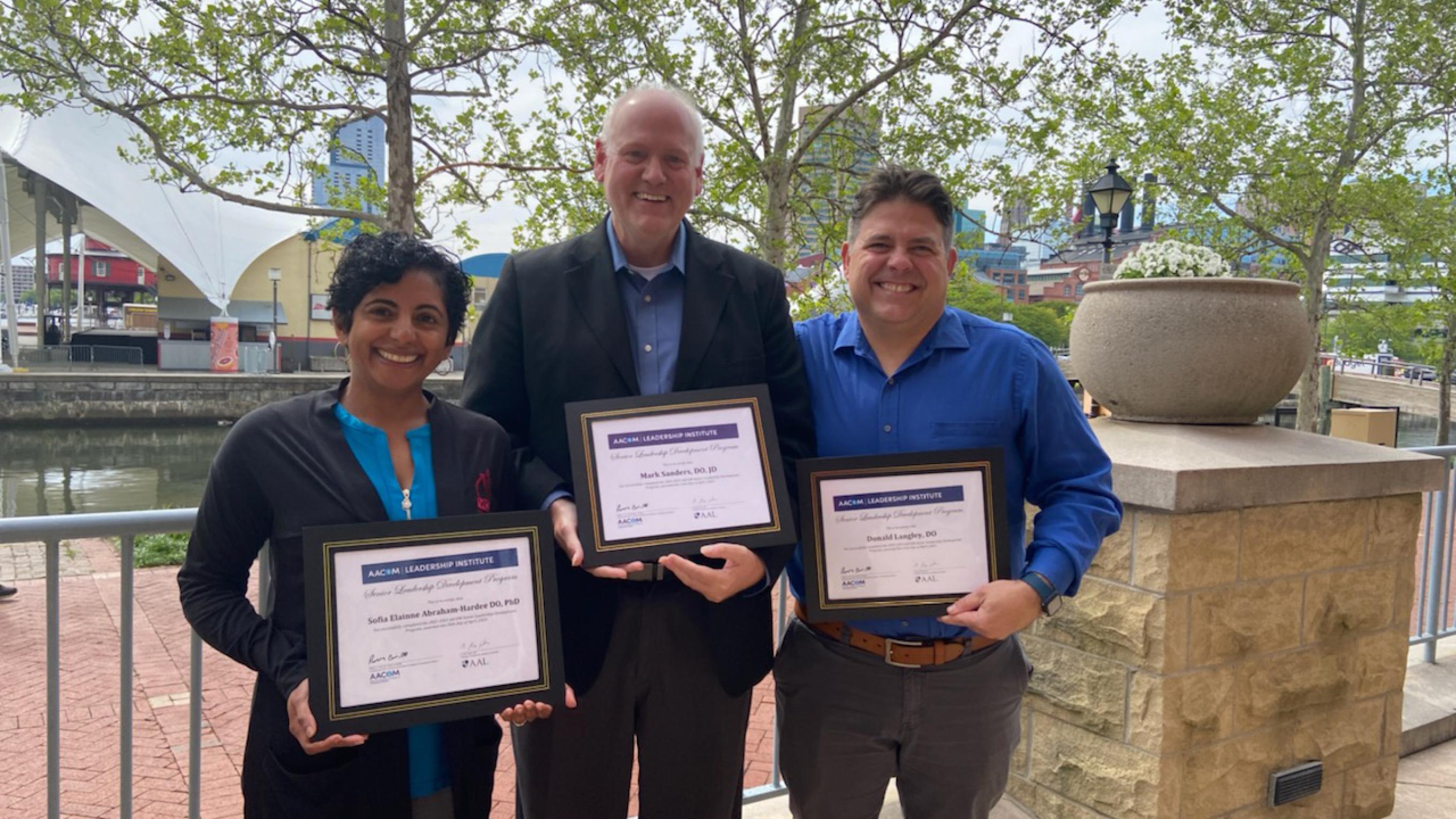 VCOM administrators posing with certificates