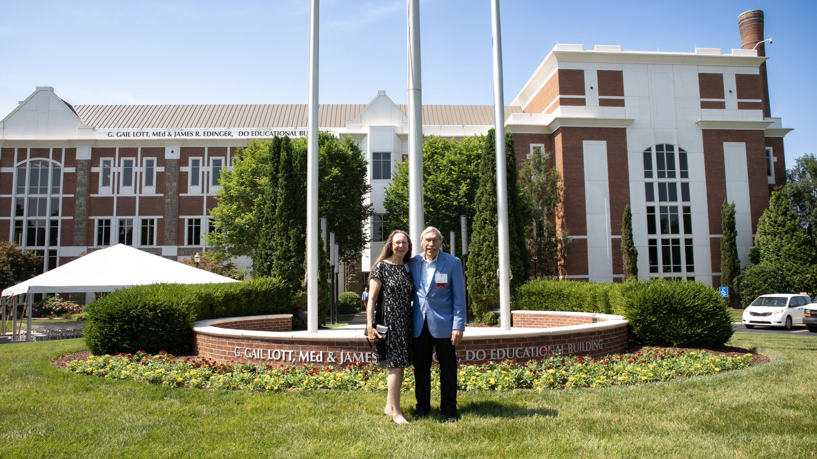 Gail Lott and James Edinger standing in front of the building displaying their name