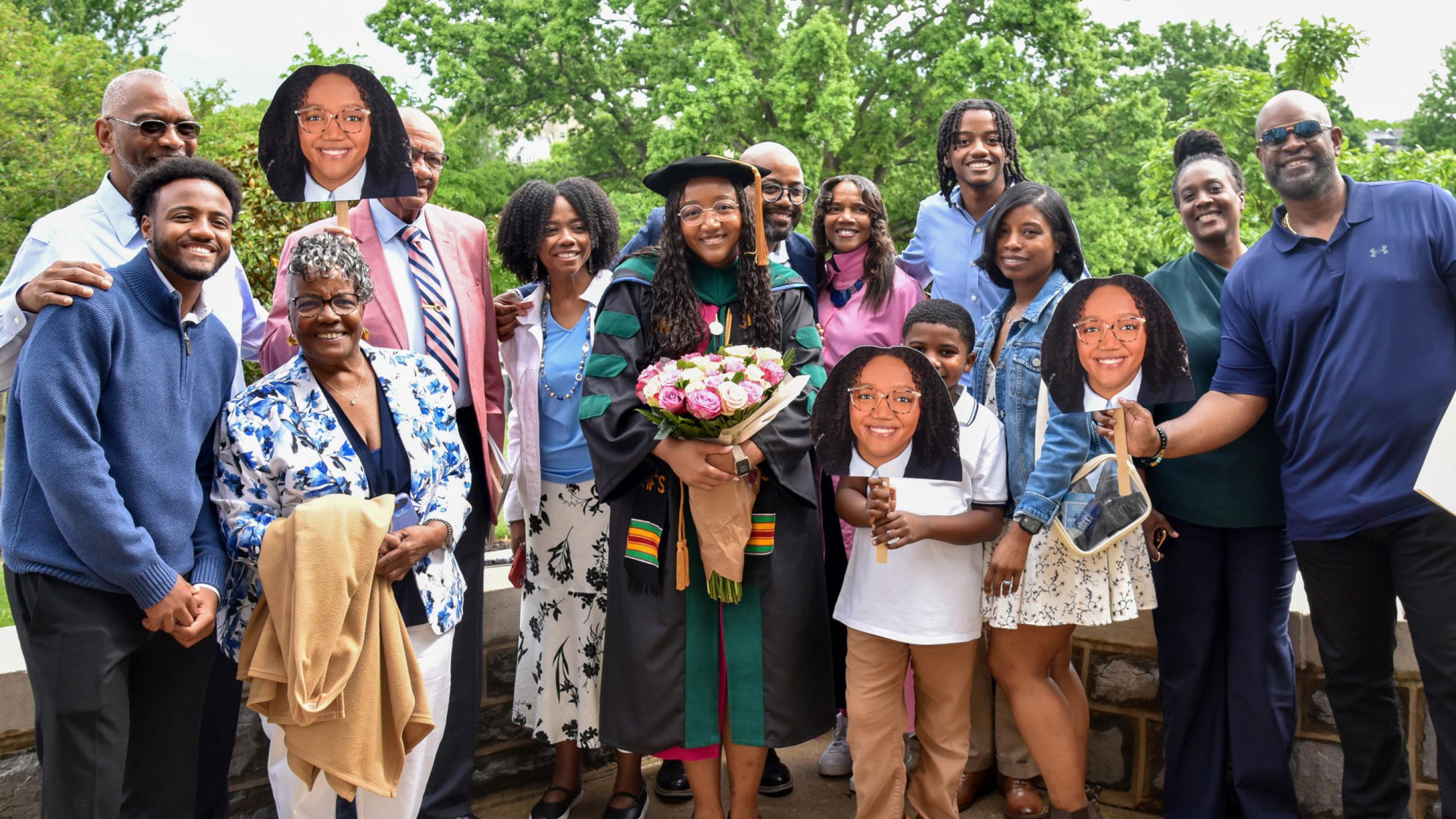 VCOM-Virginia class of 2025 graduate holding flowers and posing with her happy family