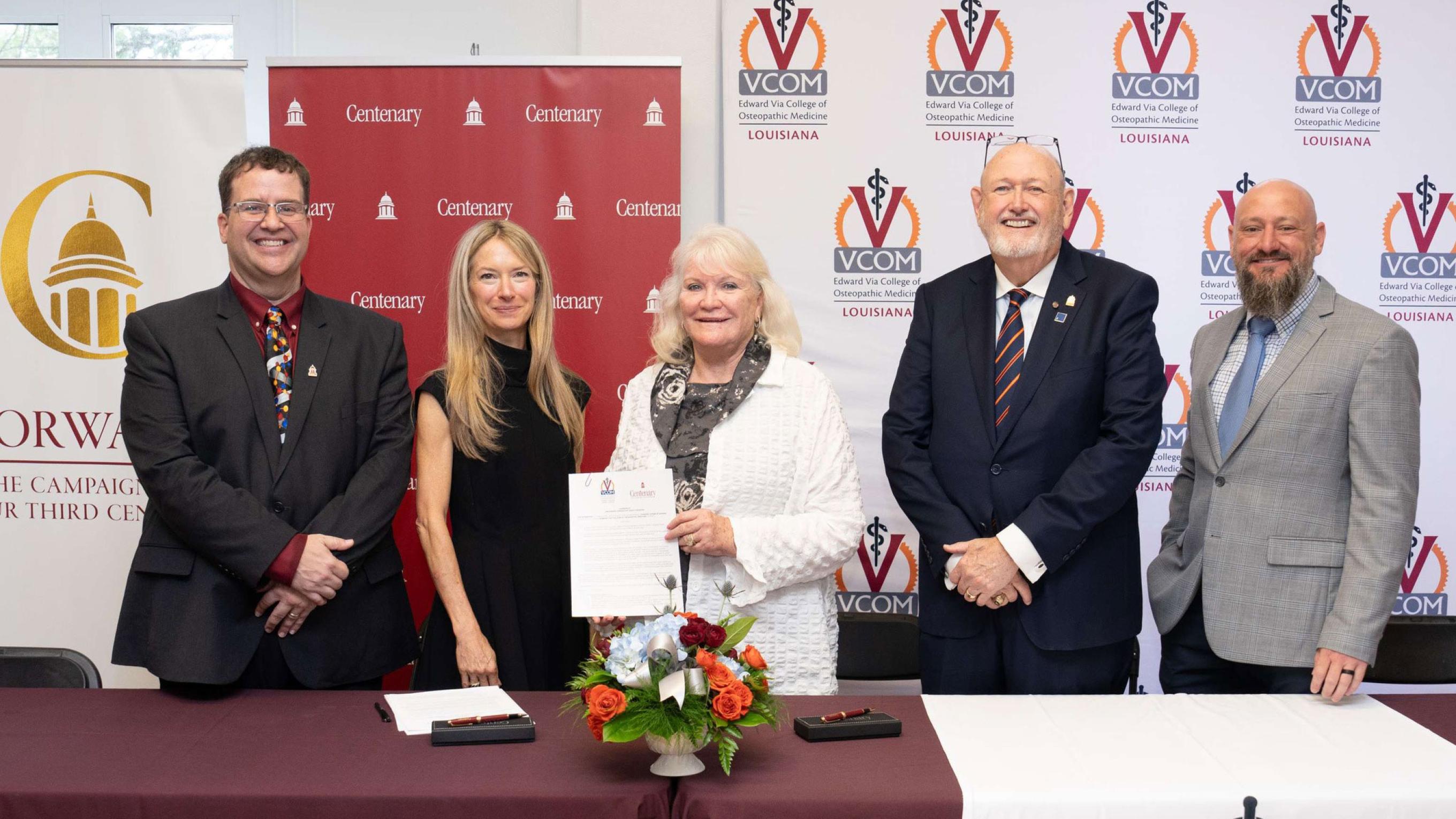 Centenary College and VCOM members smiling and holding signed articulation agreement