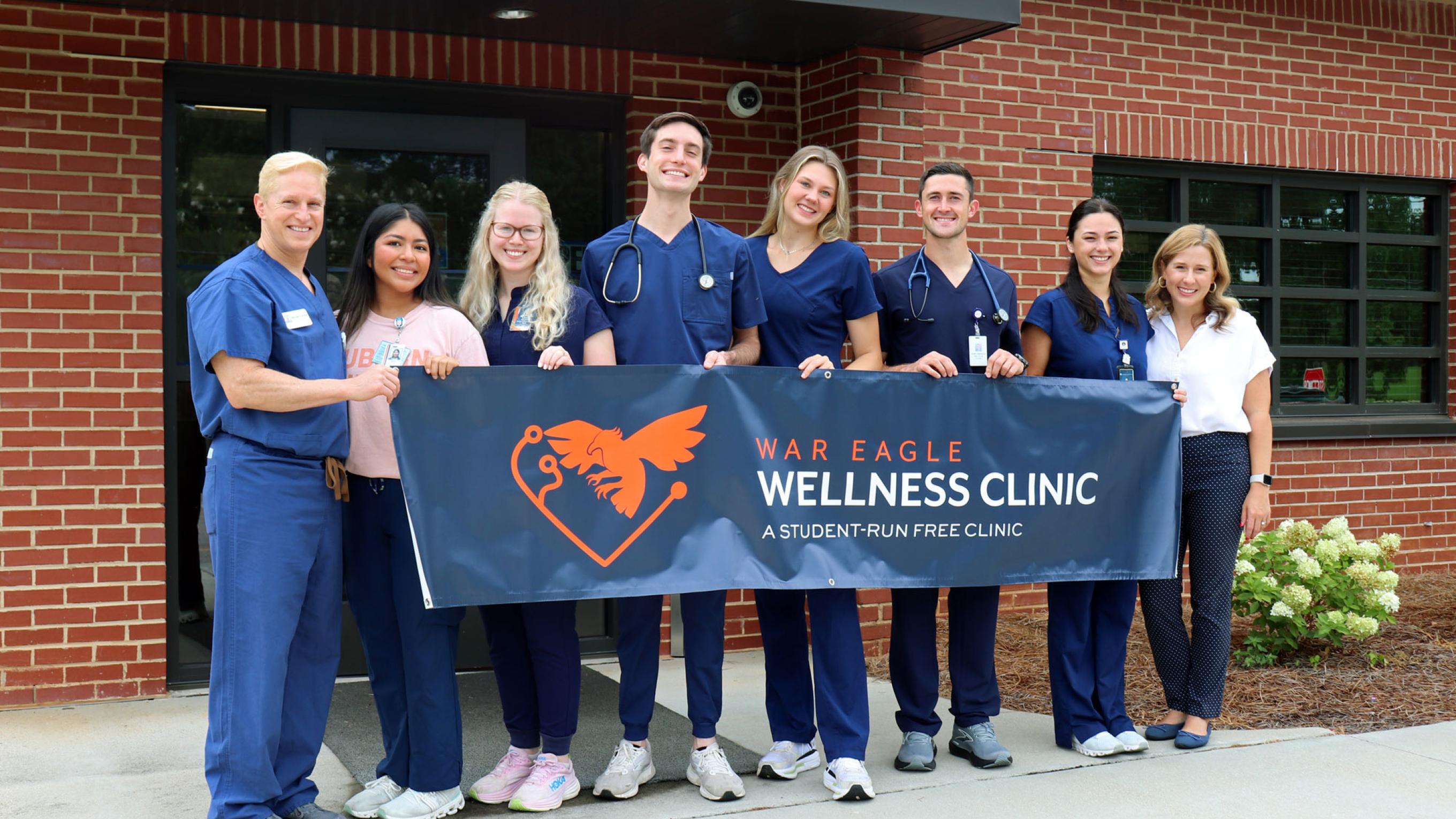 VCOM-Auburn students and staff holding a banner for the War Eagle Wellness Clinic