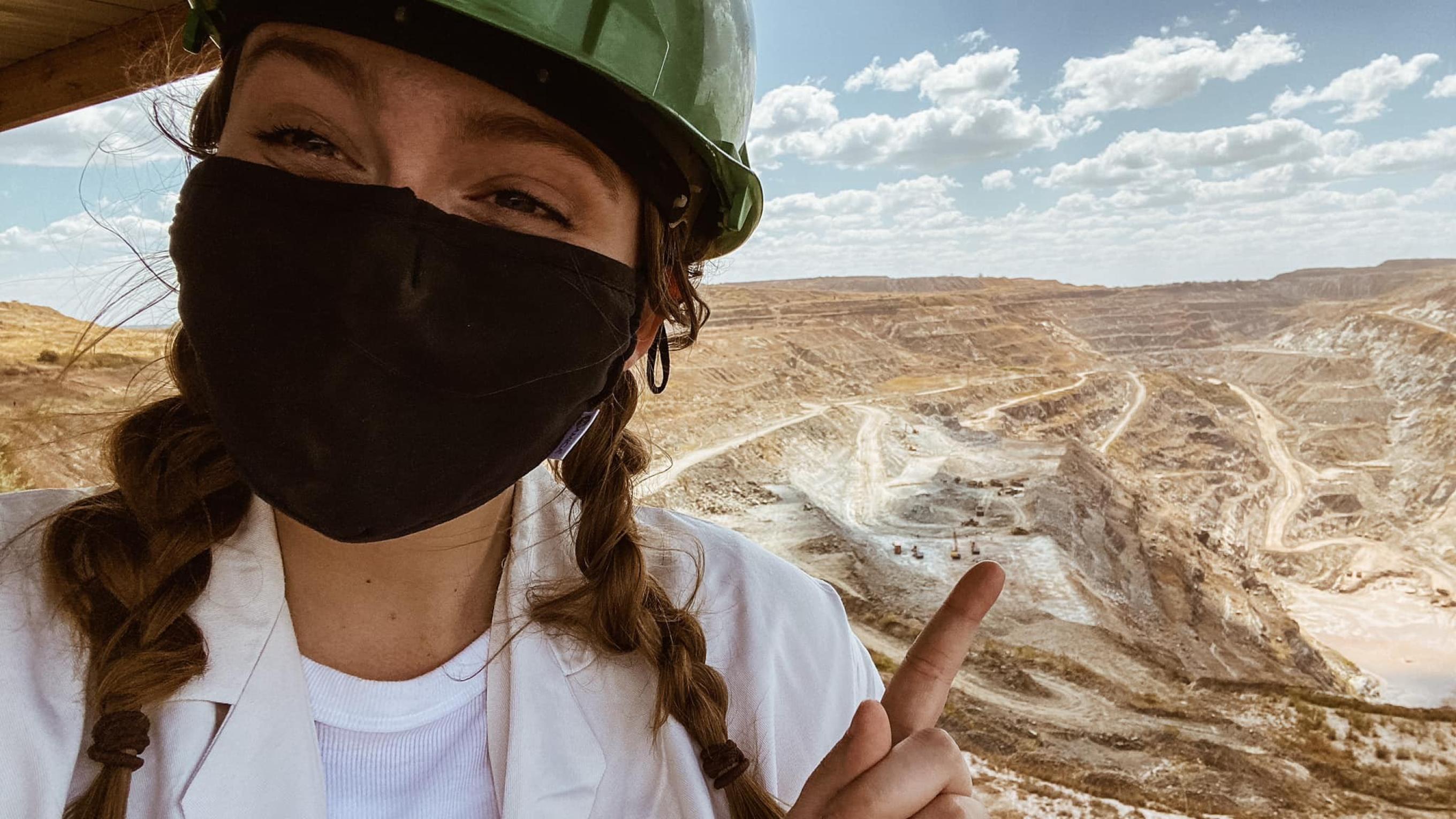 Abby Logan in a mask overlooking a mining site