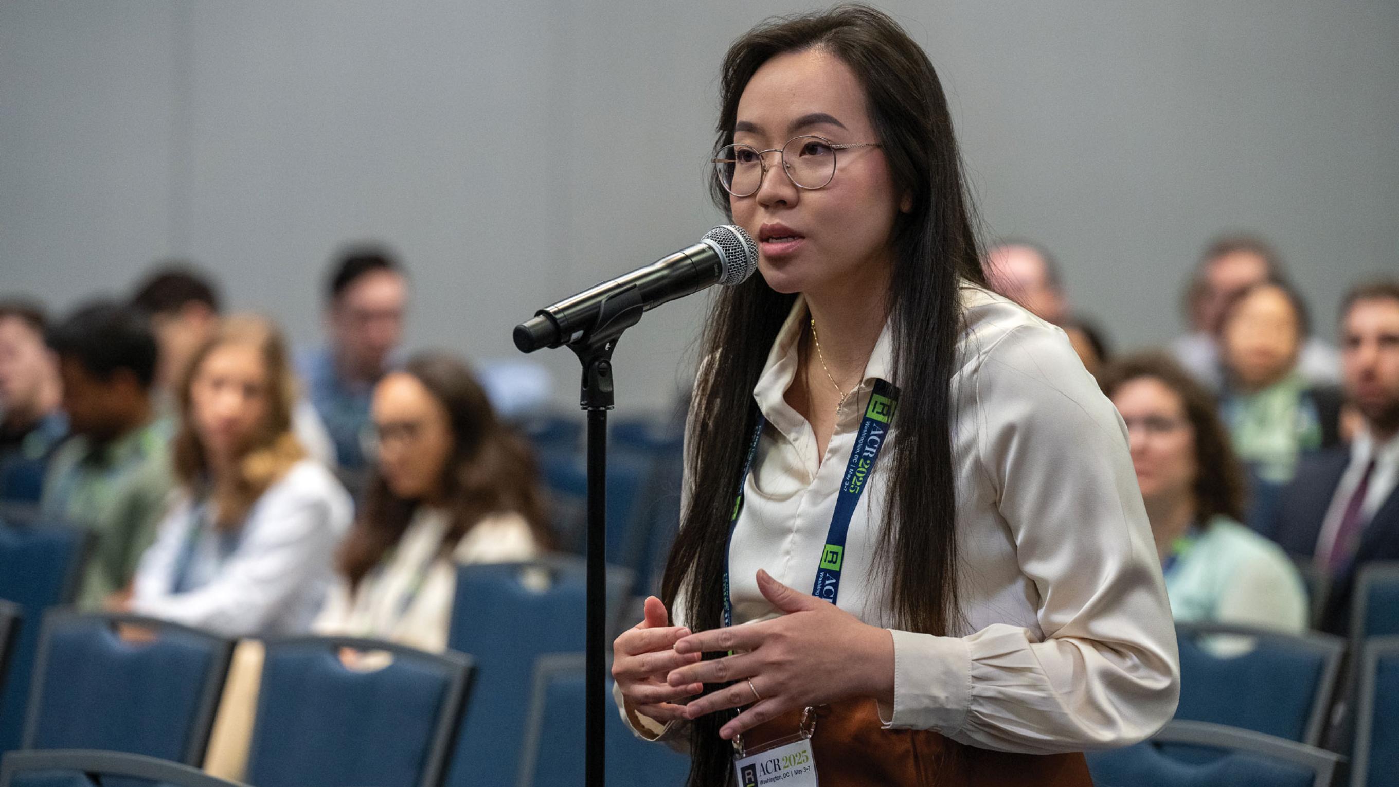 Annie Pham standing and speaking into a microphone