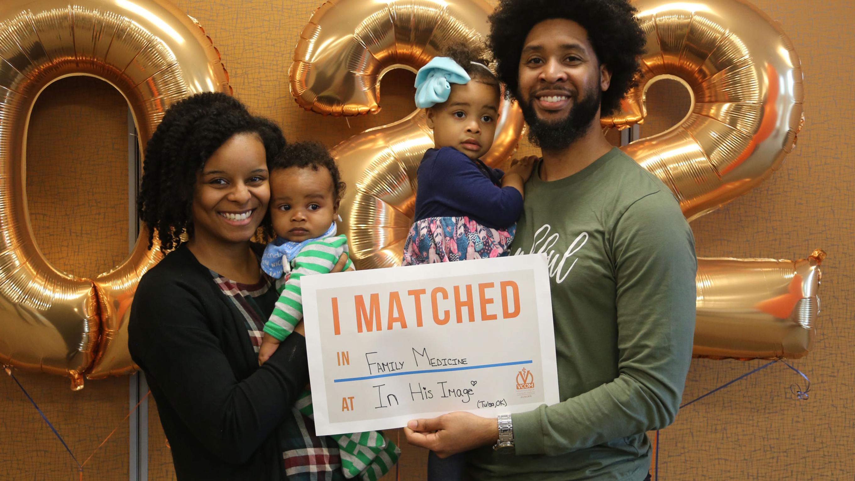 VCOM-Carolinas student with family holding up a match day sign