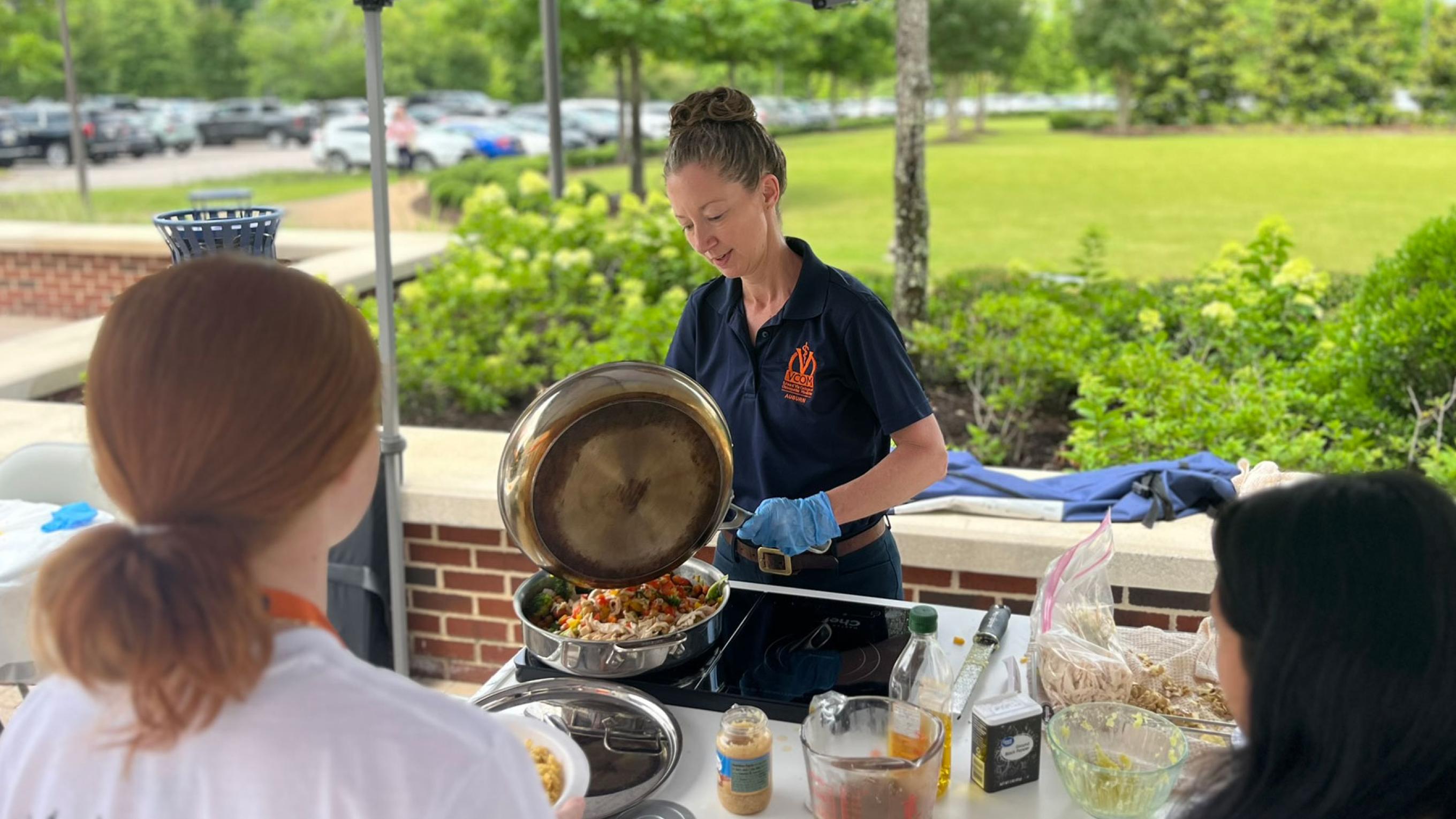 Dr. Annie Kirby cooking food outside for students.