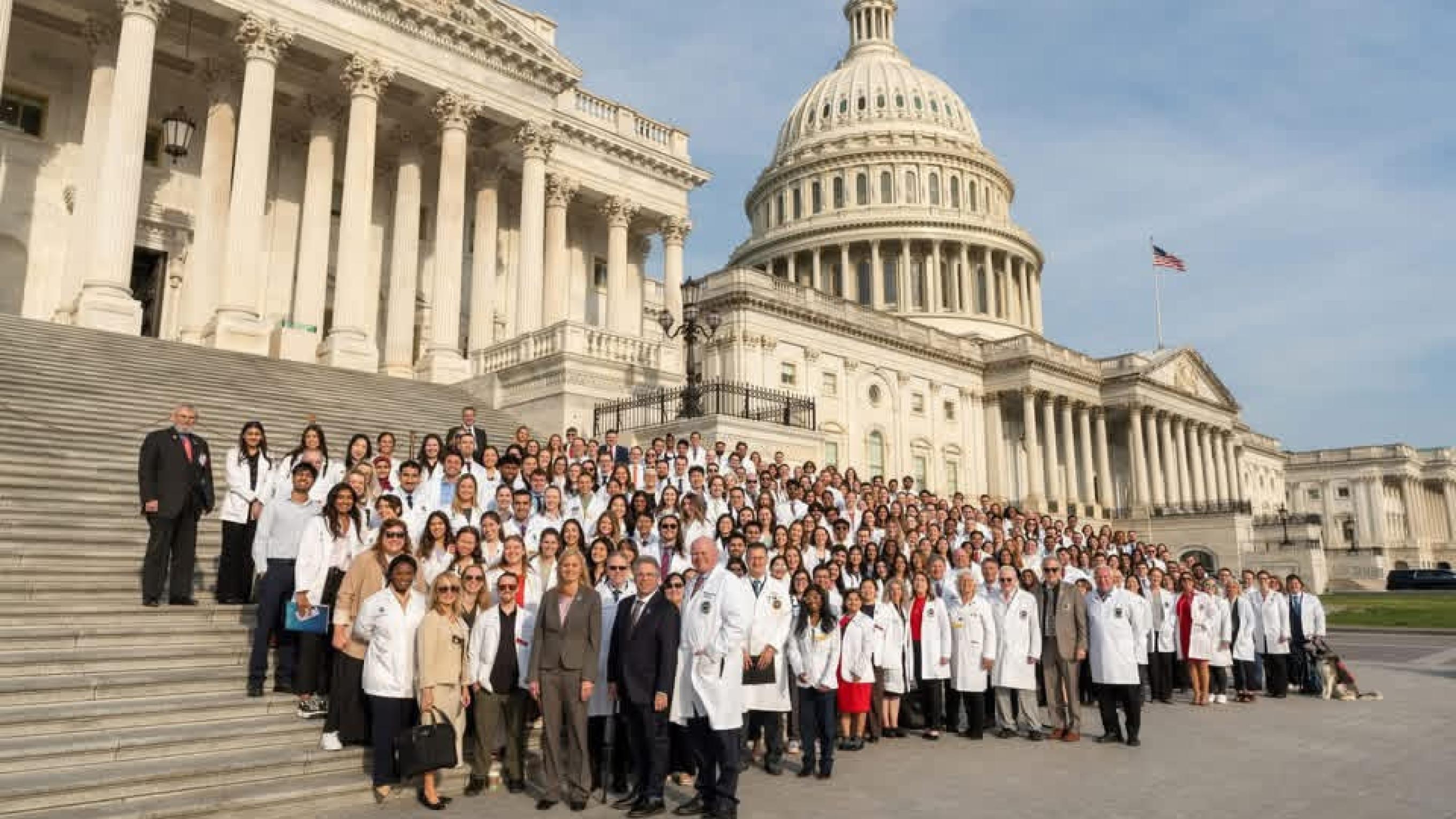Large group of student doctors standing on the steps of the Capitol building
