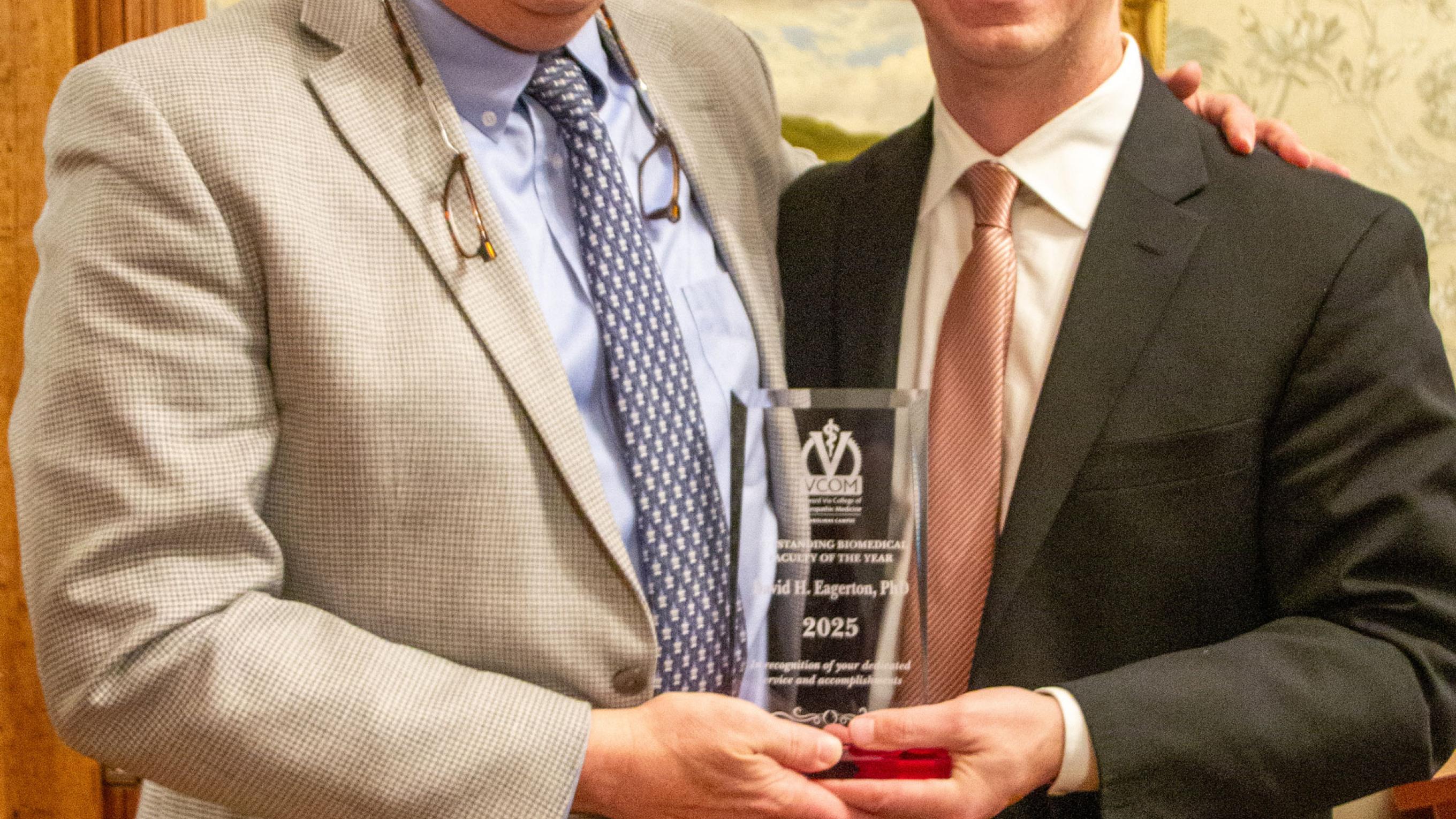 Dr Eagerton and Dr Cannon smiling while holding award