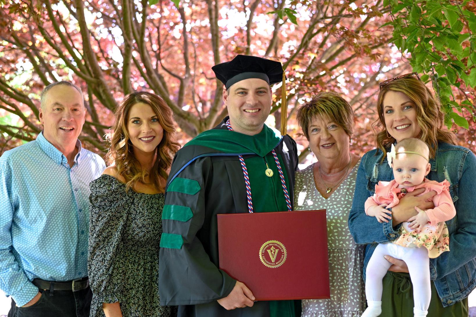 graduate posing with family