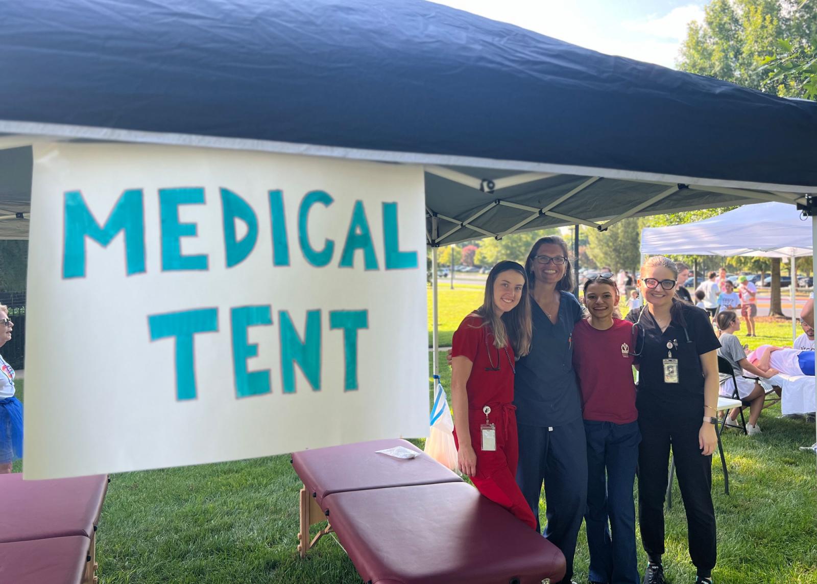 VCOM students standing under a medical tent