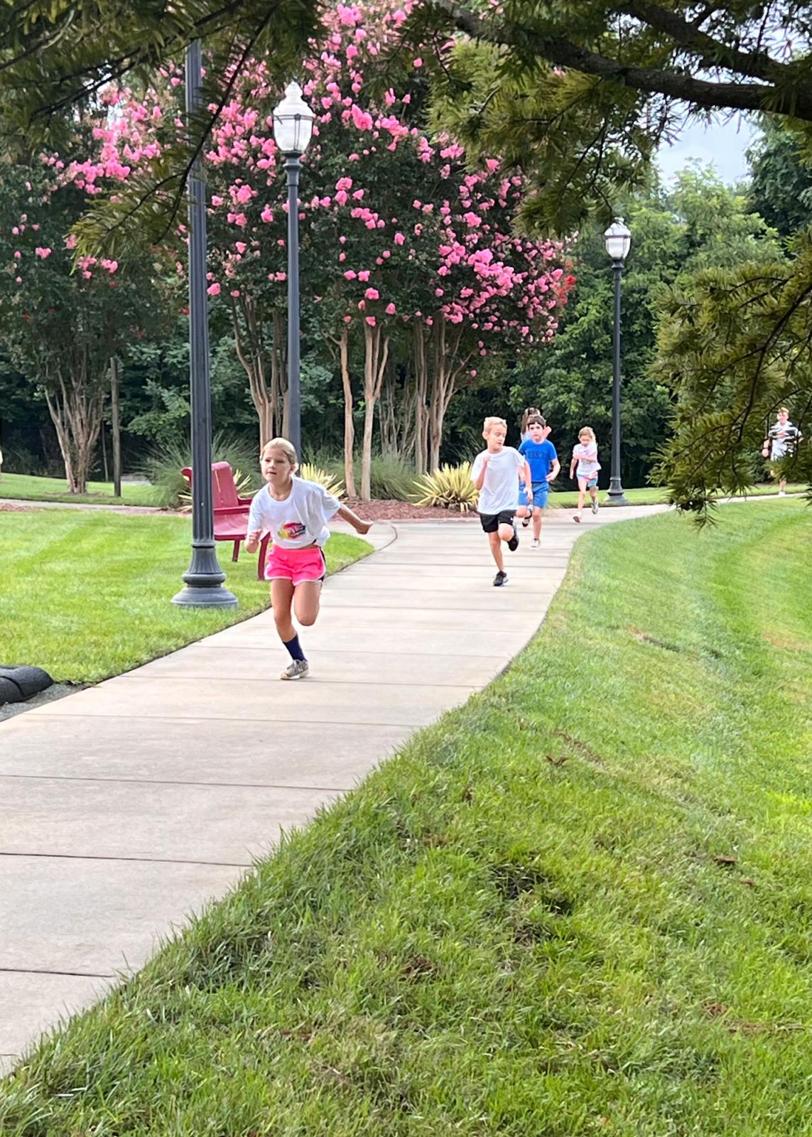 Children running down a sidewalk