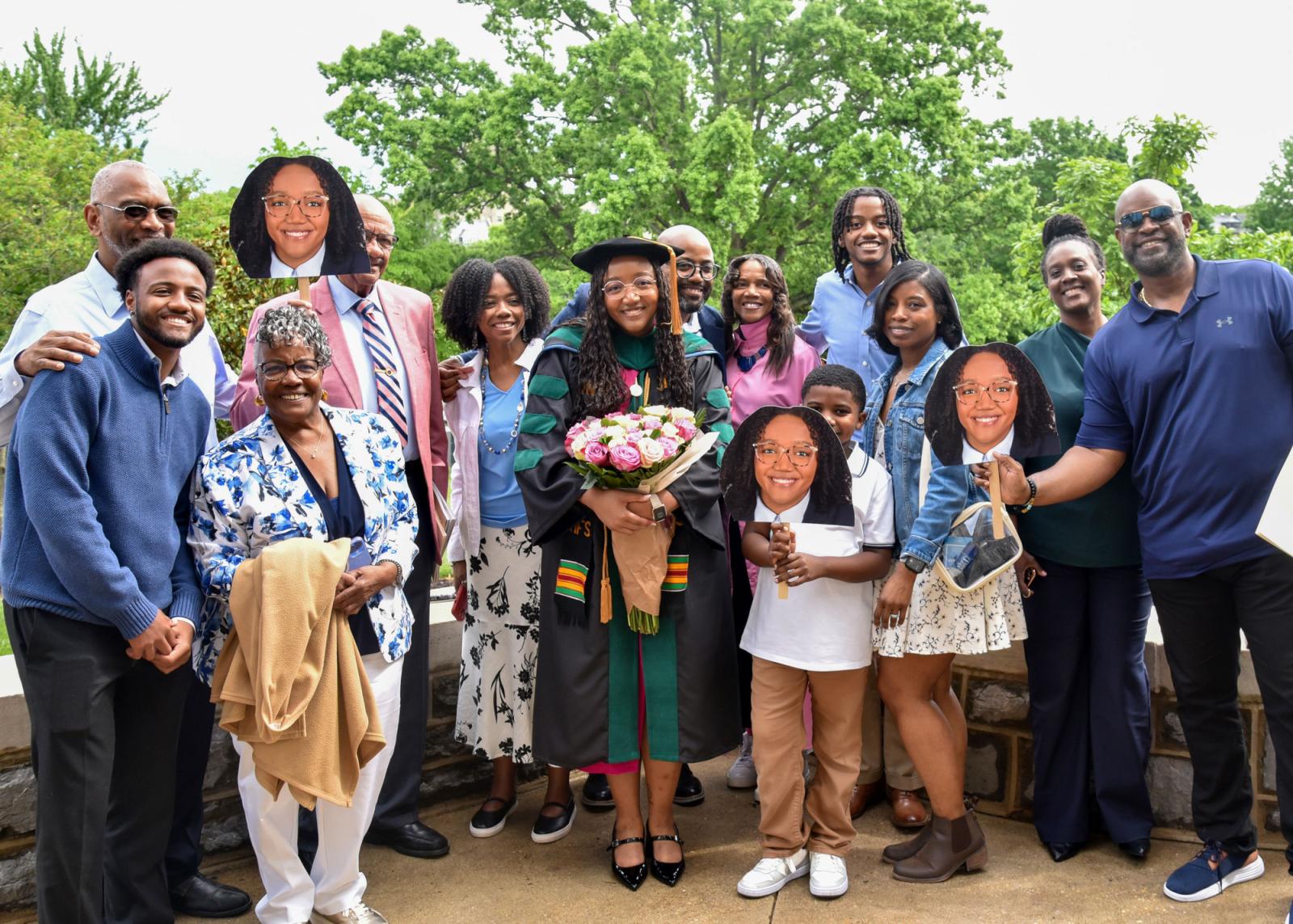 VCOM-Virginia class of 2025 graduate holding flowers and posing with her happy family