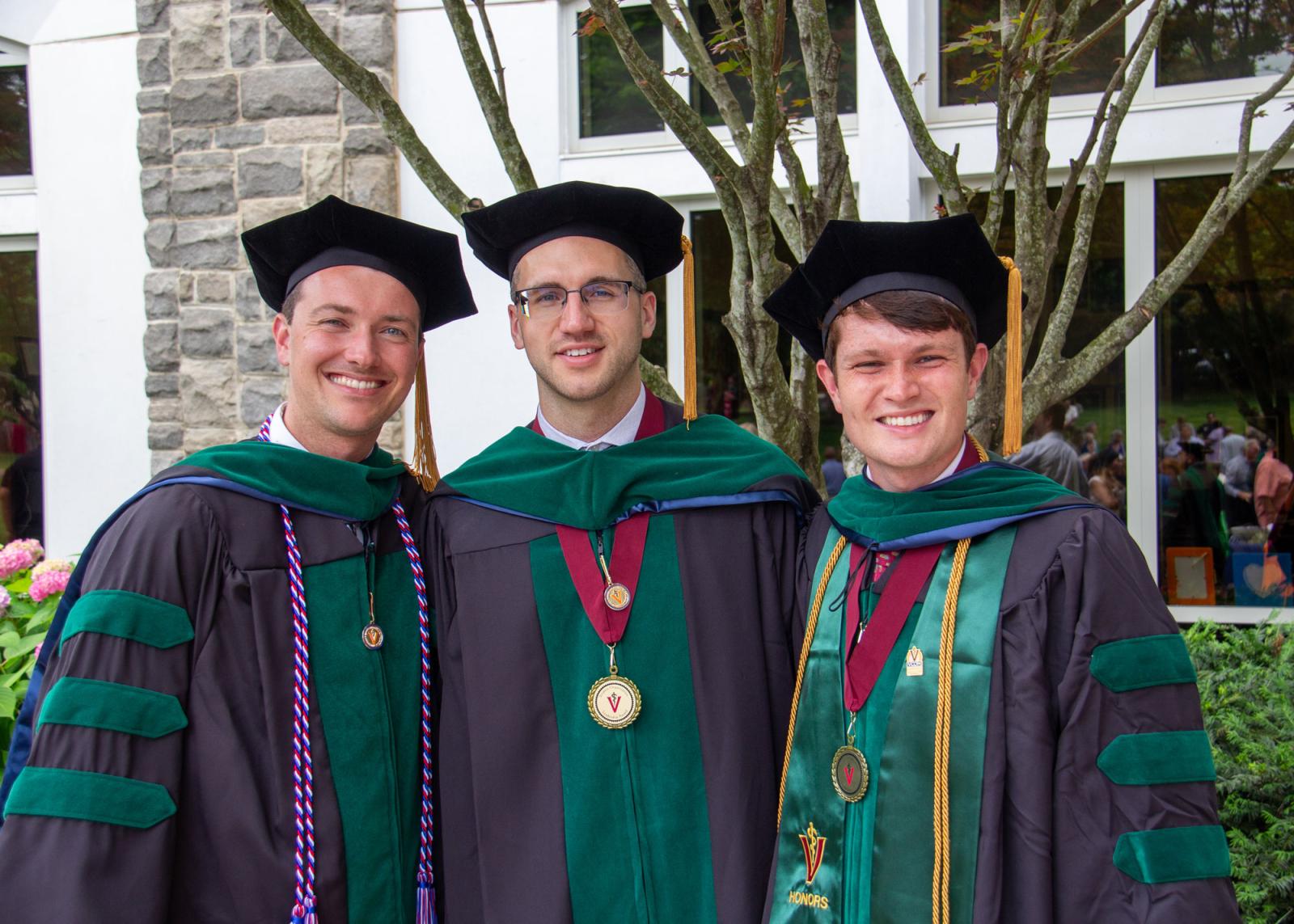 Three VCOM class of 2025 graduates in regalia smiling