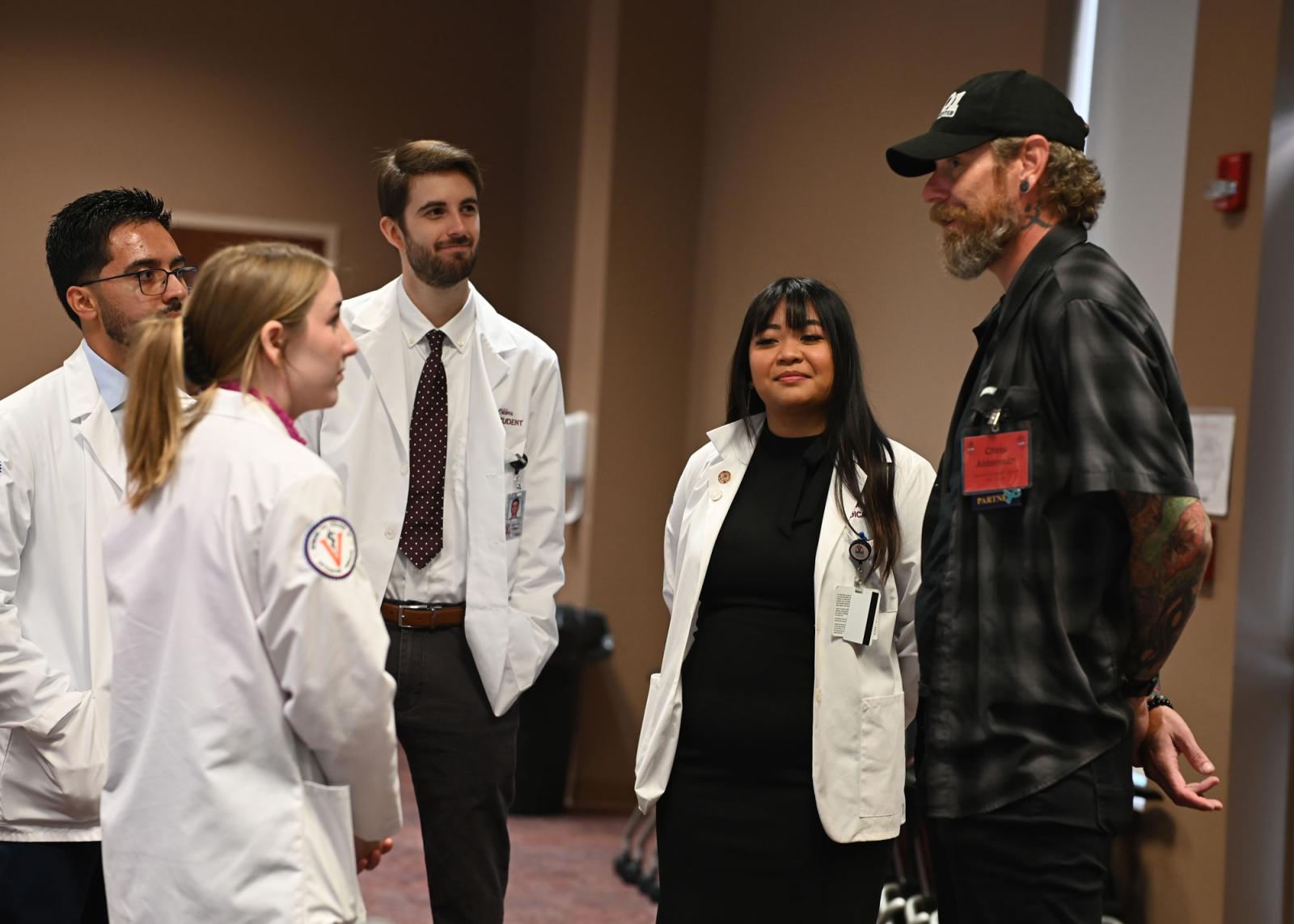 VCOM-Virginia students in white coats speaking to a CORE symposium attendee