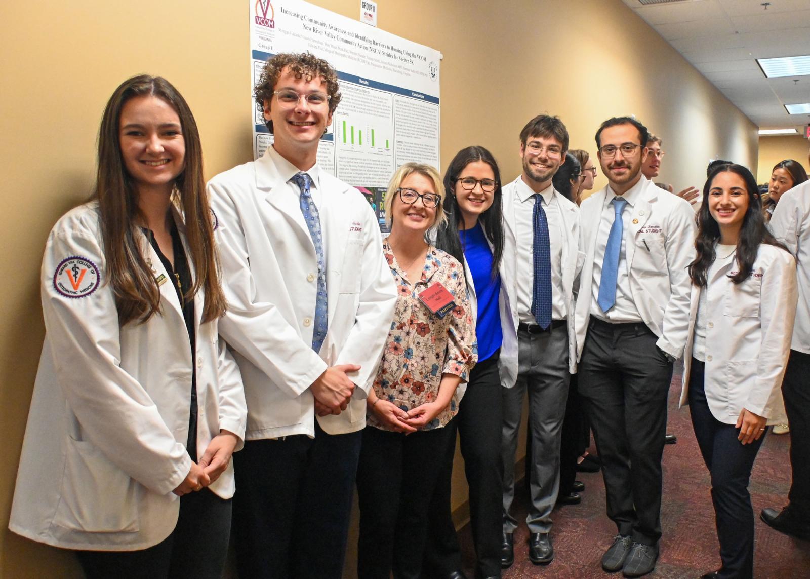 VCOM-Virginia students in white coats smiling during the CORE symposium.
