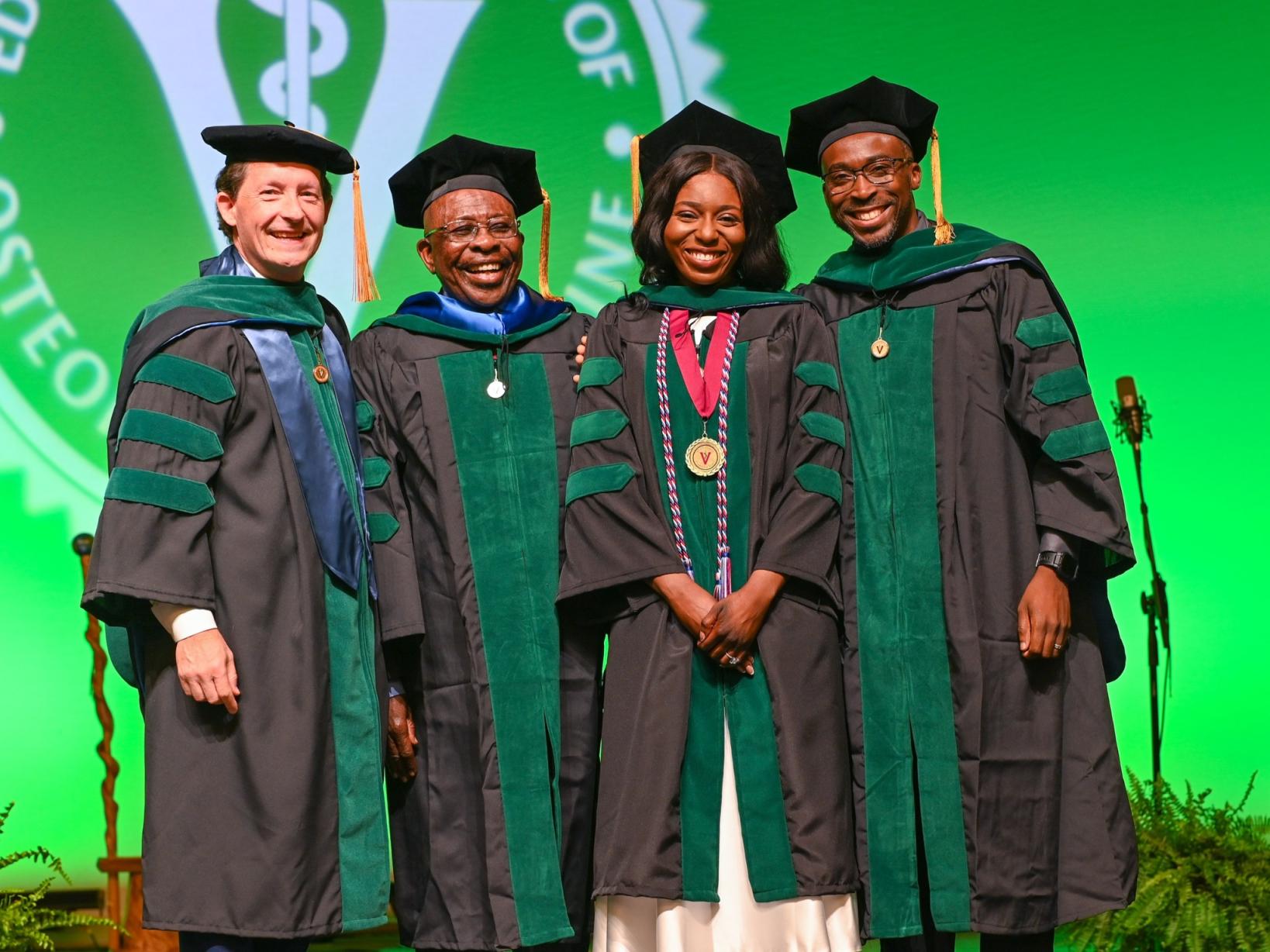 VCOM-Virginia president with class of 2026 graduate and her family on stage smiling