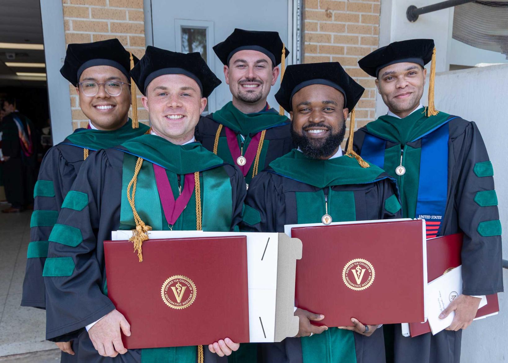 VCOM Louisiana class of 2026 graduates holding diplomas and smiling