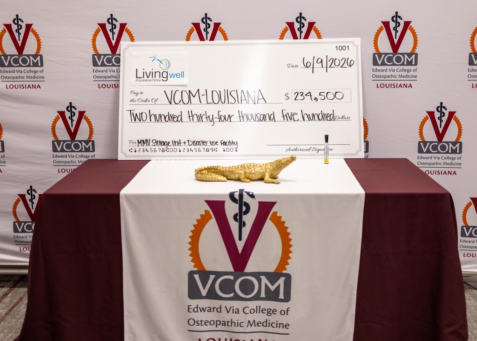Oversized check sitting on a table at VCOM-Louisiana