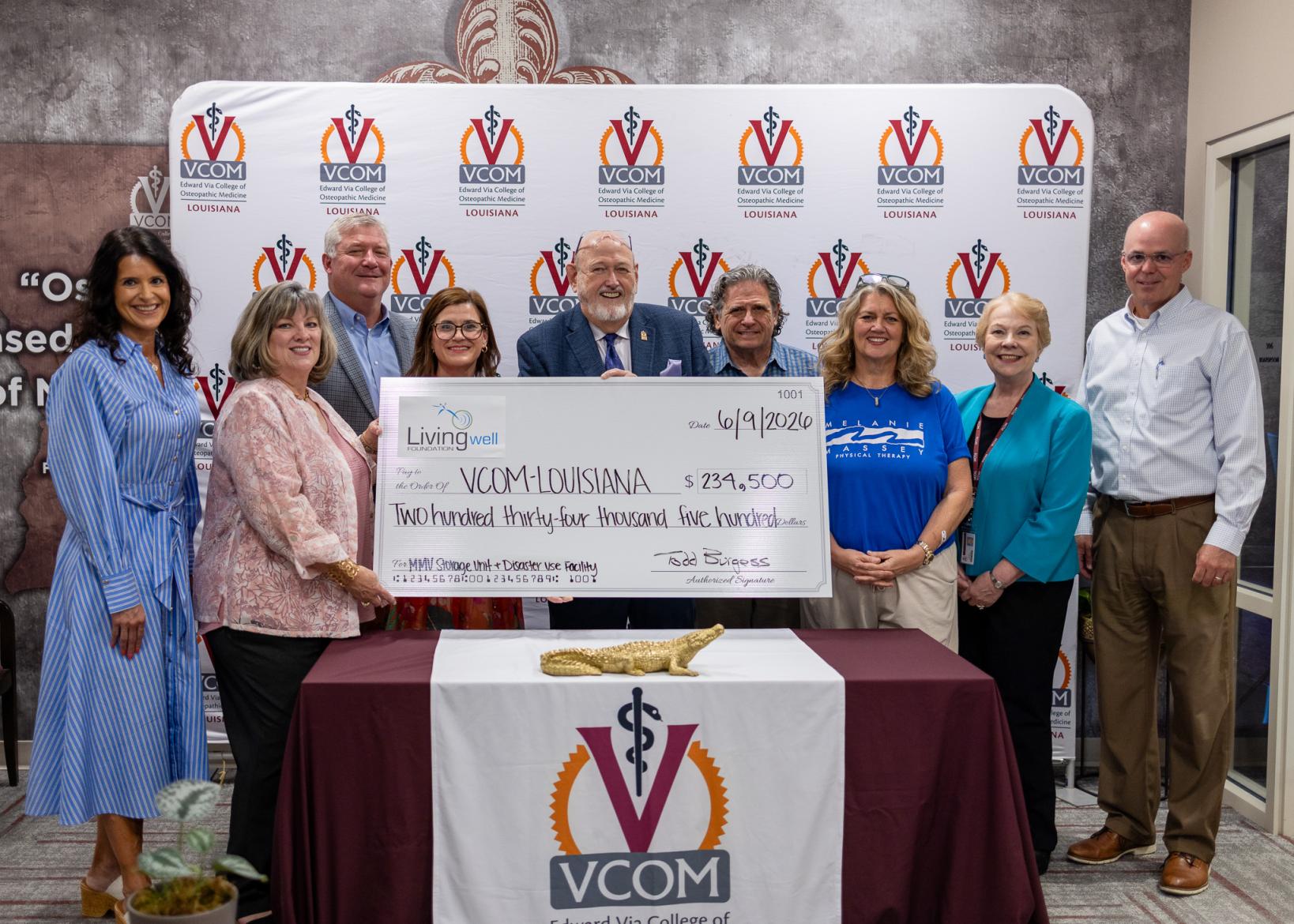 Large group holding an oversized check at VCOM-Louisiana