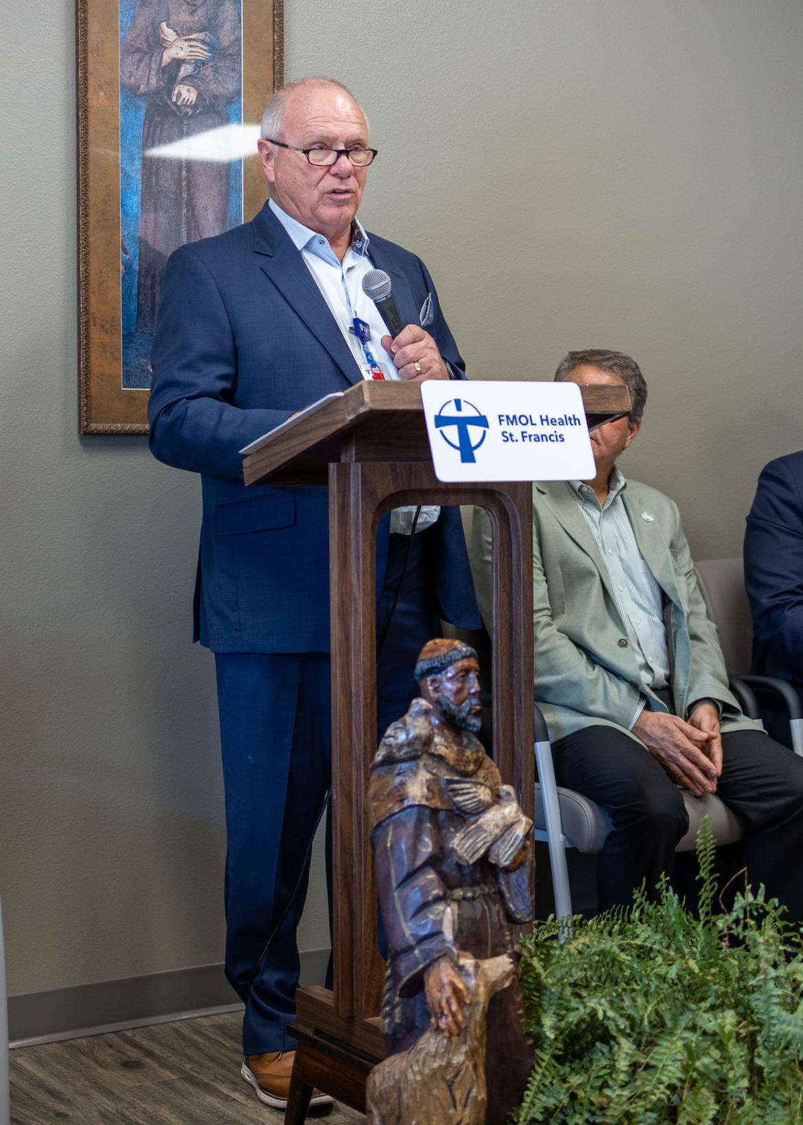 Person standing at a podium addressing the crowd
