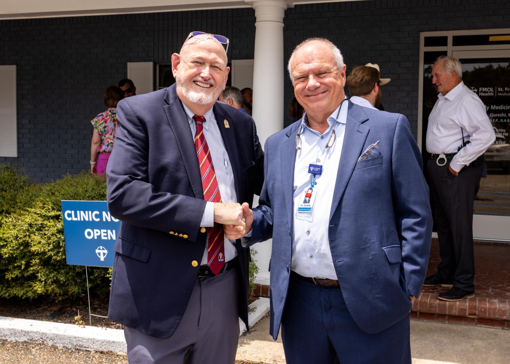 two men shaking hands and smiling