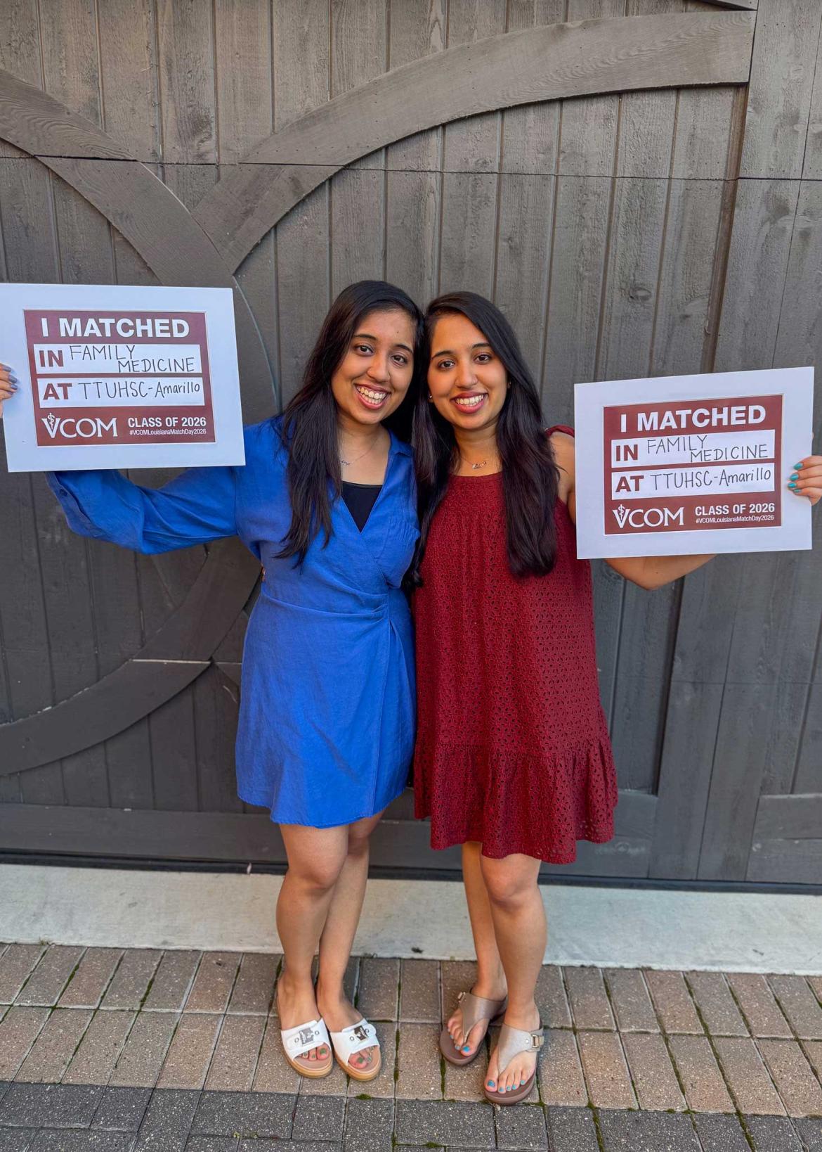 Drs. Ishani and Shivani Sharma holding their match day signs