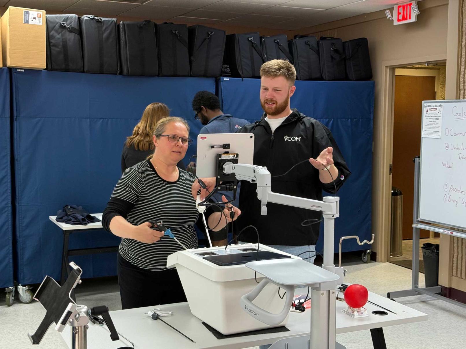 David Grace, VCOM-Virginia '28, works with a Radford University Nursing student on the laparoscopic trainer he developed.