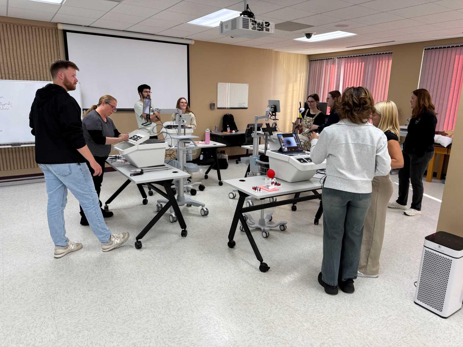 Students in a classroom working with laparoscopic trainers