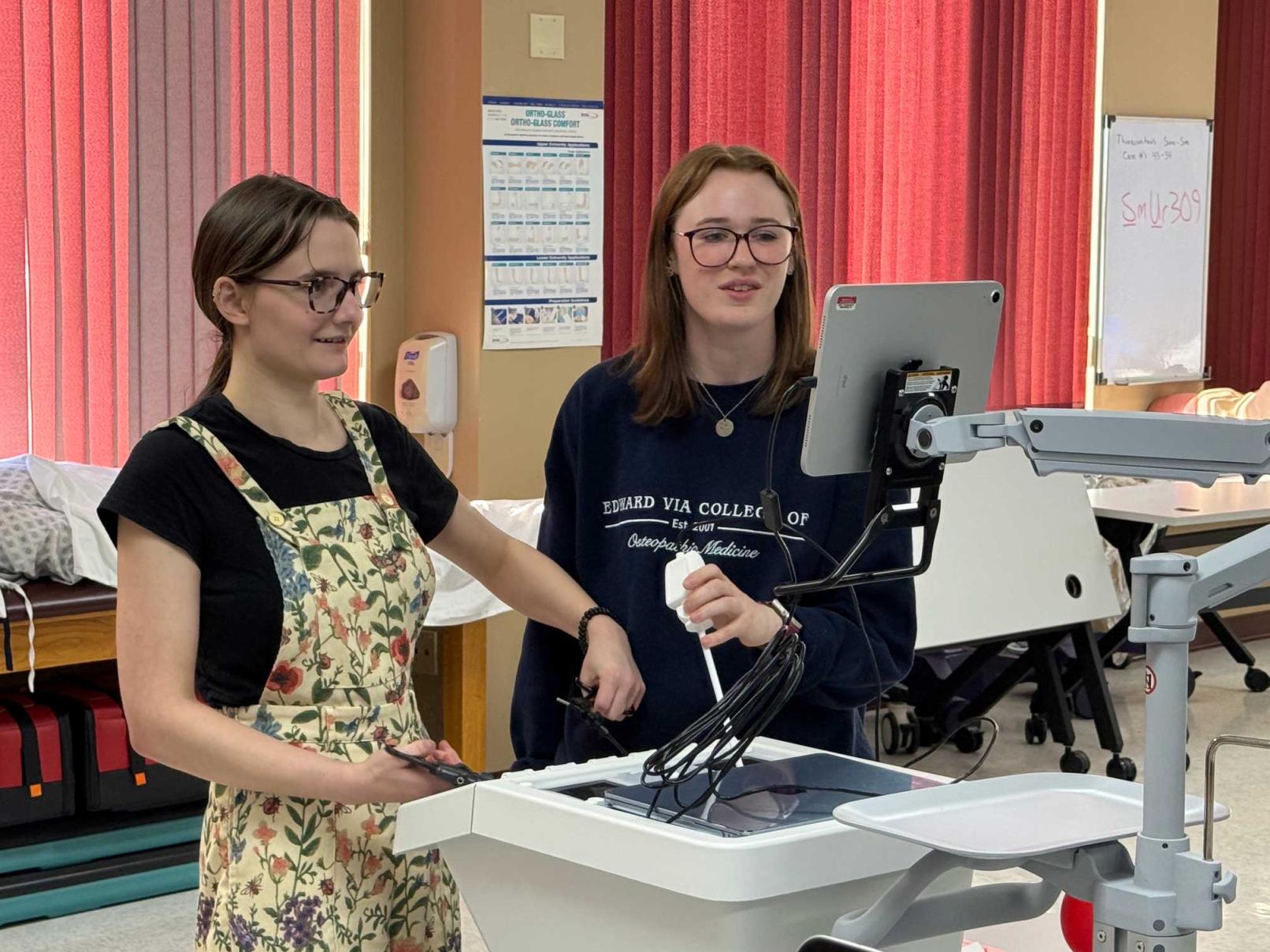 Two students in a classroom working with laparoscopic trainer