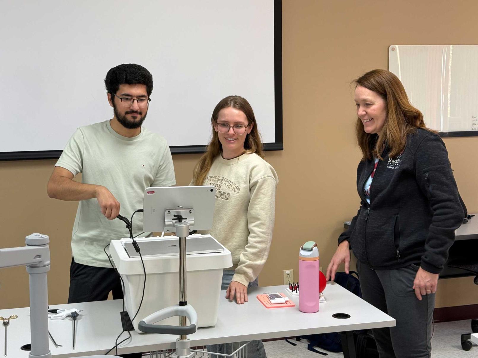 Students in a classroom working with laparoscopic trainers