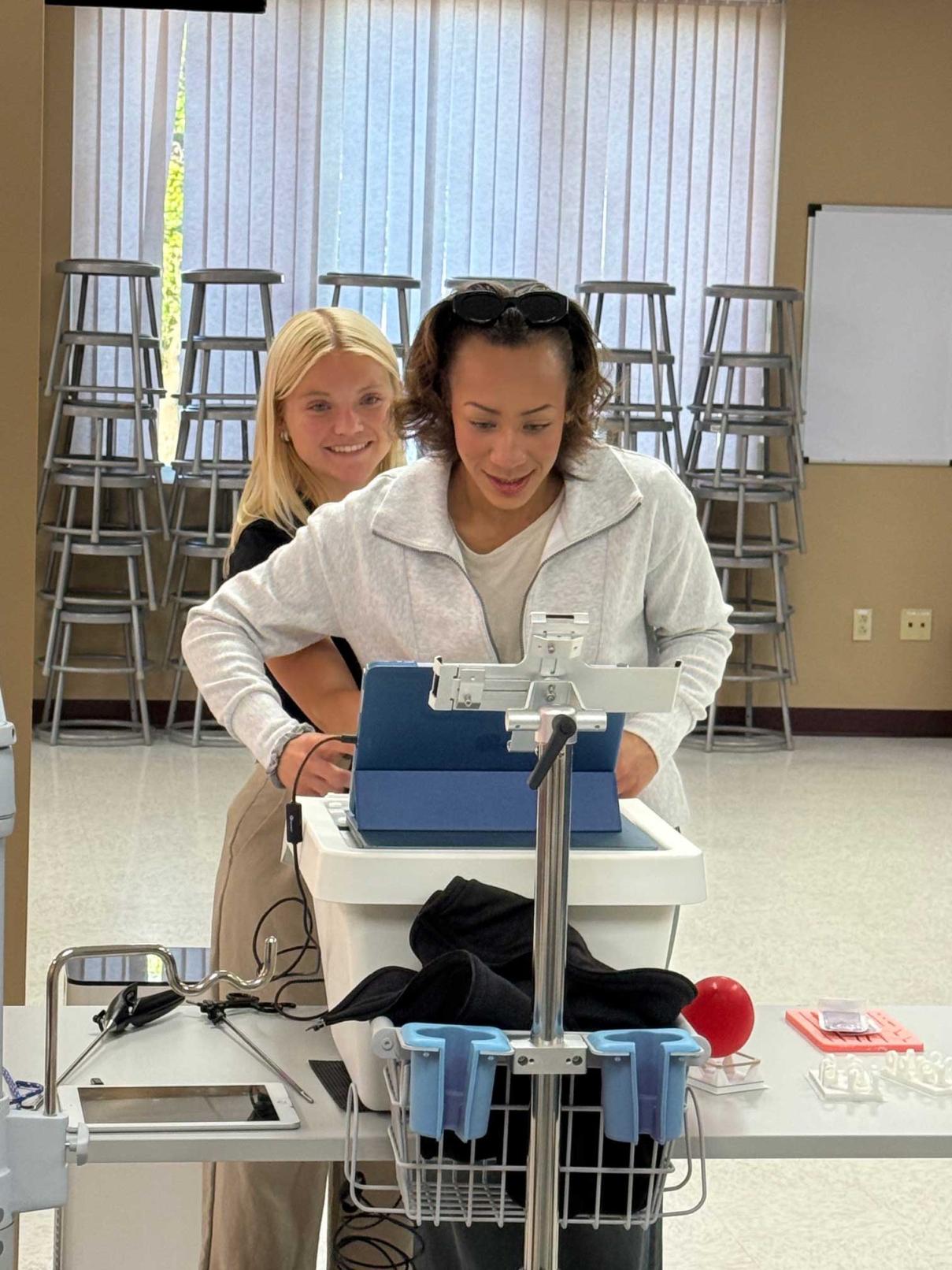 Two students in a classroom working with laparoscopic trainer