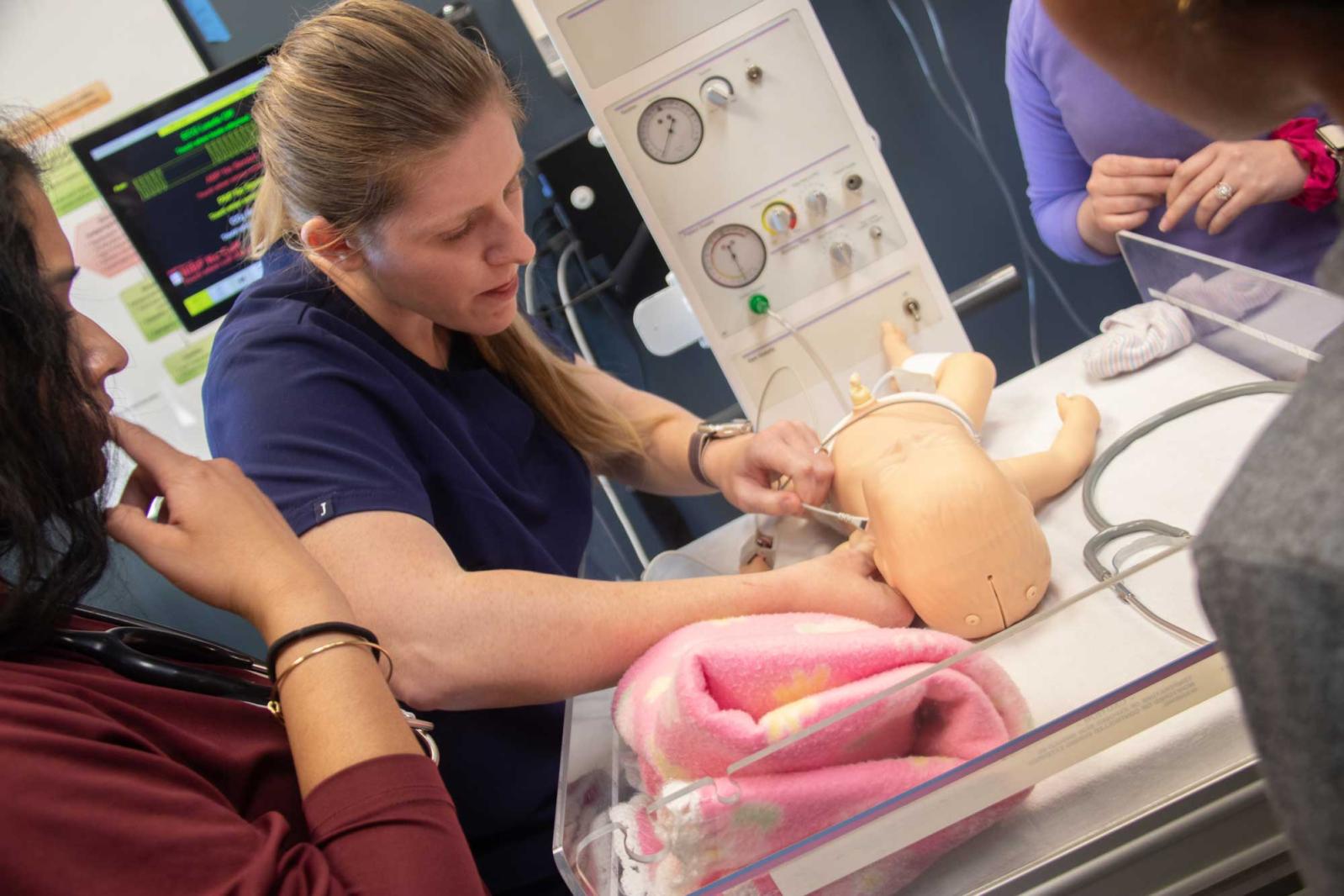 Medical students working with a pedatric manikin