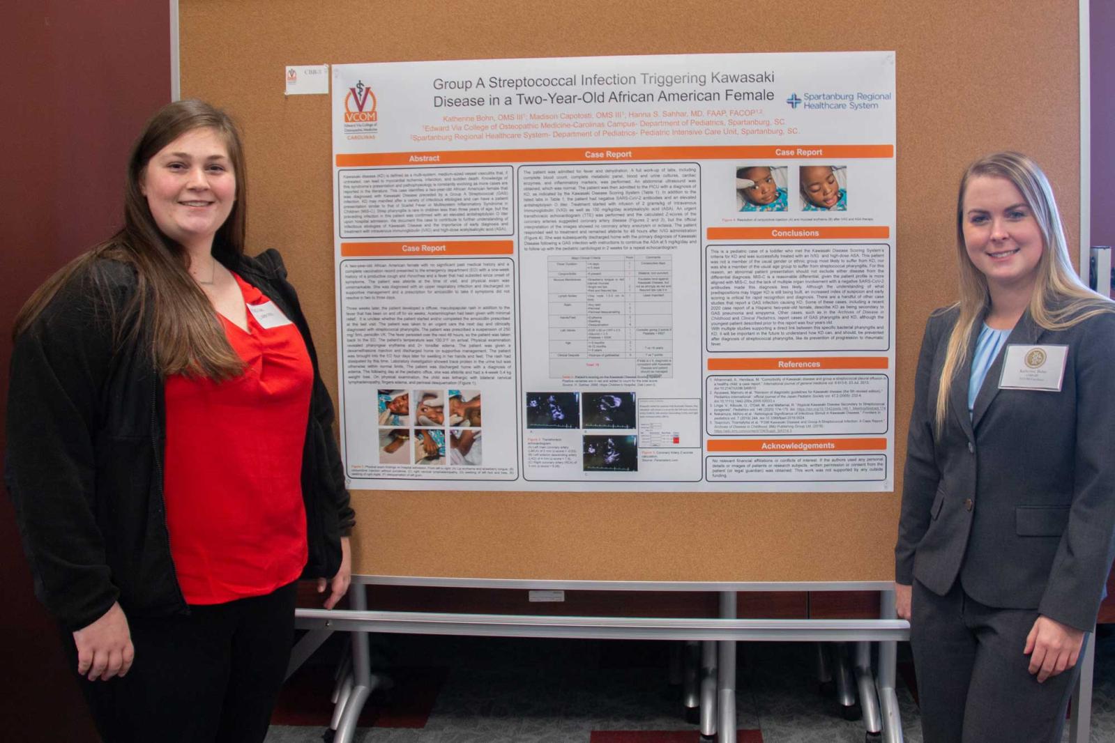 Medical student standing in front of their research day poster