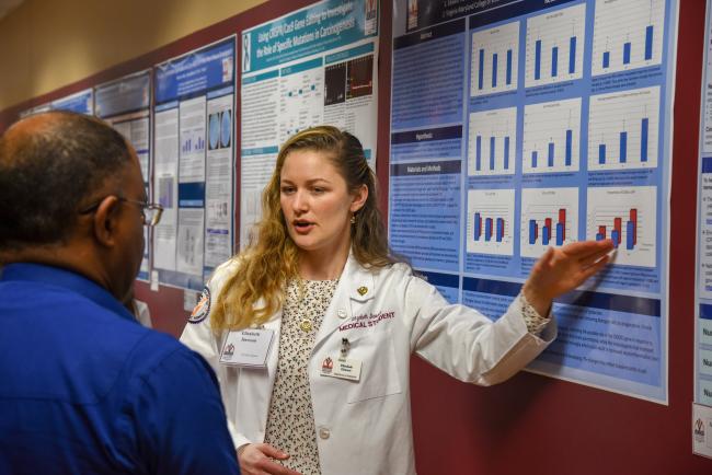 research day student discussing project poster