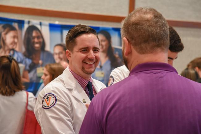 medical student engaging with a professor at a school event