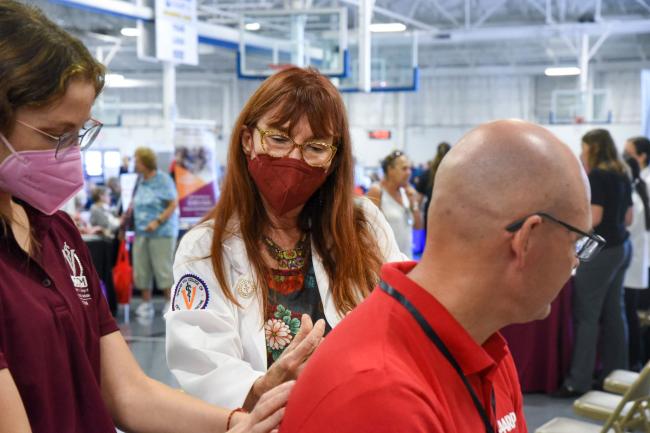 Dr. Willcox guiding a medical student with patient at an AARP Health Fair