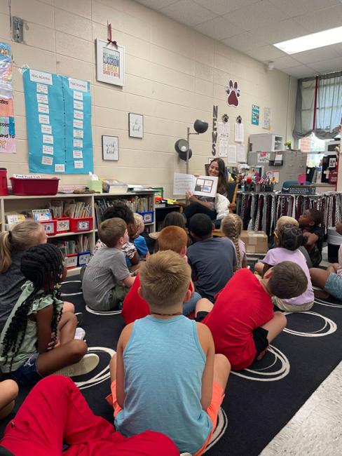 VCOM Auburn student reading to a class of children