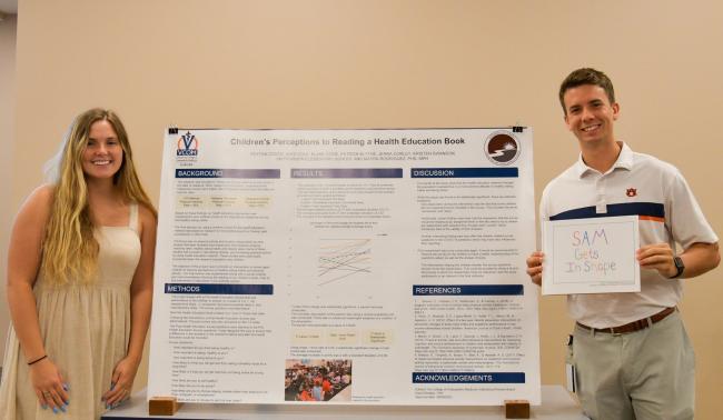 VCOM Auburn students standing in front of research poster
