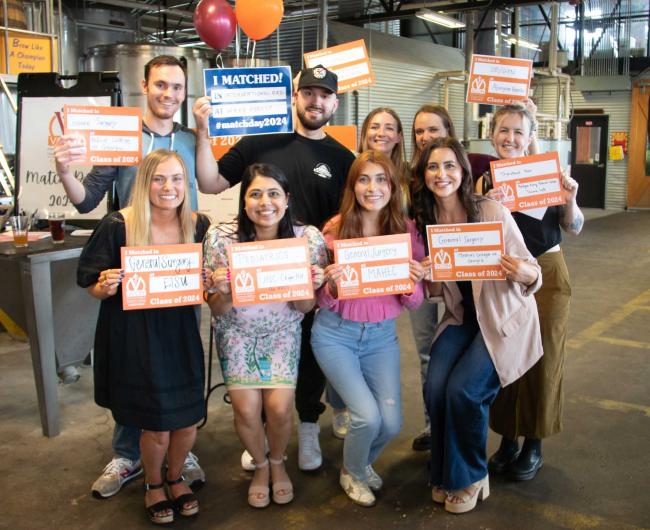 Carolinas students posing with match day posters