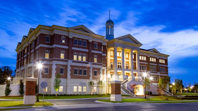 VCOM Louisiana building at dusk with lights glowing