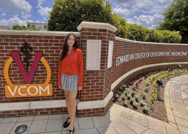 Faith Baxter standing in front of VCOM Carolinas entrance