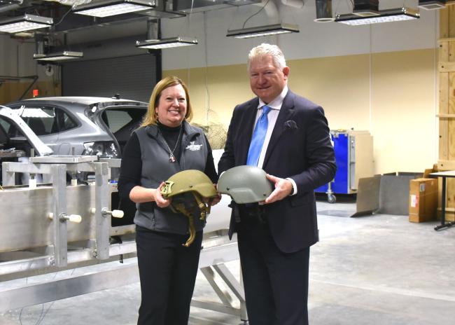 Dr Brolinson and Dr VandeVord holding helmets and smiling