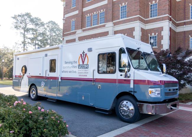 Mobile medical unit parked in front of VCOM-Louisiana campus building