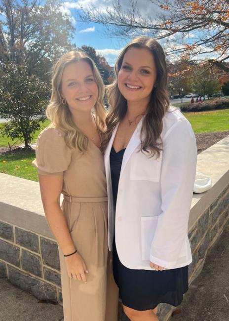 Erin Onken wearing a white coat posing with a friend