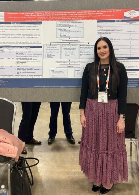 Courtney Pisano standing in front of her research poster