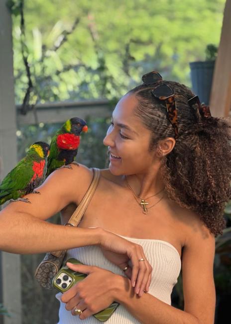 Dana Denis Lewis smiling with birds sitting on her shoulder