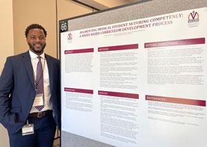Chinaemerem Chukwudoro standing in front of his poster at a research day event